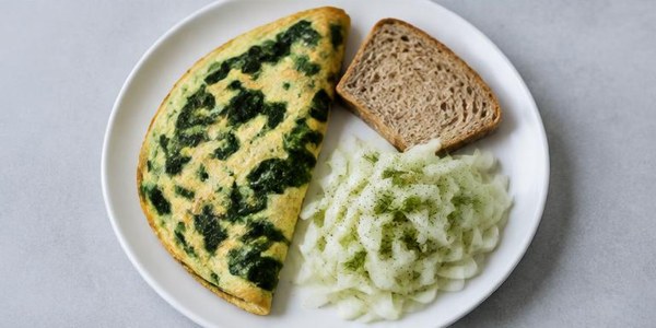 Foto illustrativa: Frittata con spinaci, pane integrale e insalata di finocchi.
