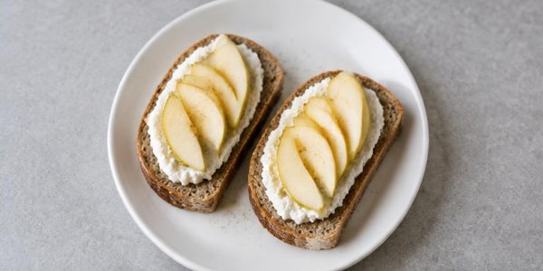 Foto illustrativa: Pane integrale con ricotta e una pera.