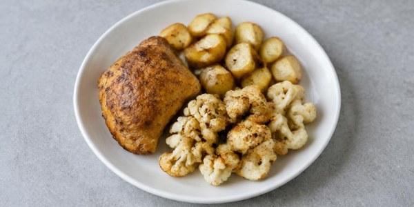Foto illustrativa: Pollo al forno con patate e cavolfiore.
